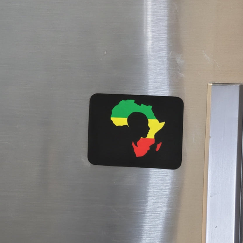 A small black rectangular sticker featuring a silhouette of Africa filled with green, yellow, and red shapes, placed on a brushed stainless steel surface.