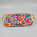 A rectangular decorative tray with gold-toned metal handles and a vibrant, multicolored geometric star pattern on the top, displayed on a black marble surface.