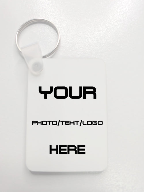 A white customizable rectangular key tag with a silver split ring, featuring placeholder black text that reads 'YOUR PHOTO/TEHT/LOGO HERE' on a light gray background.