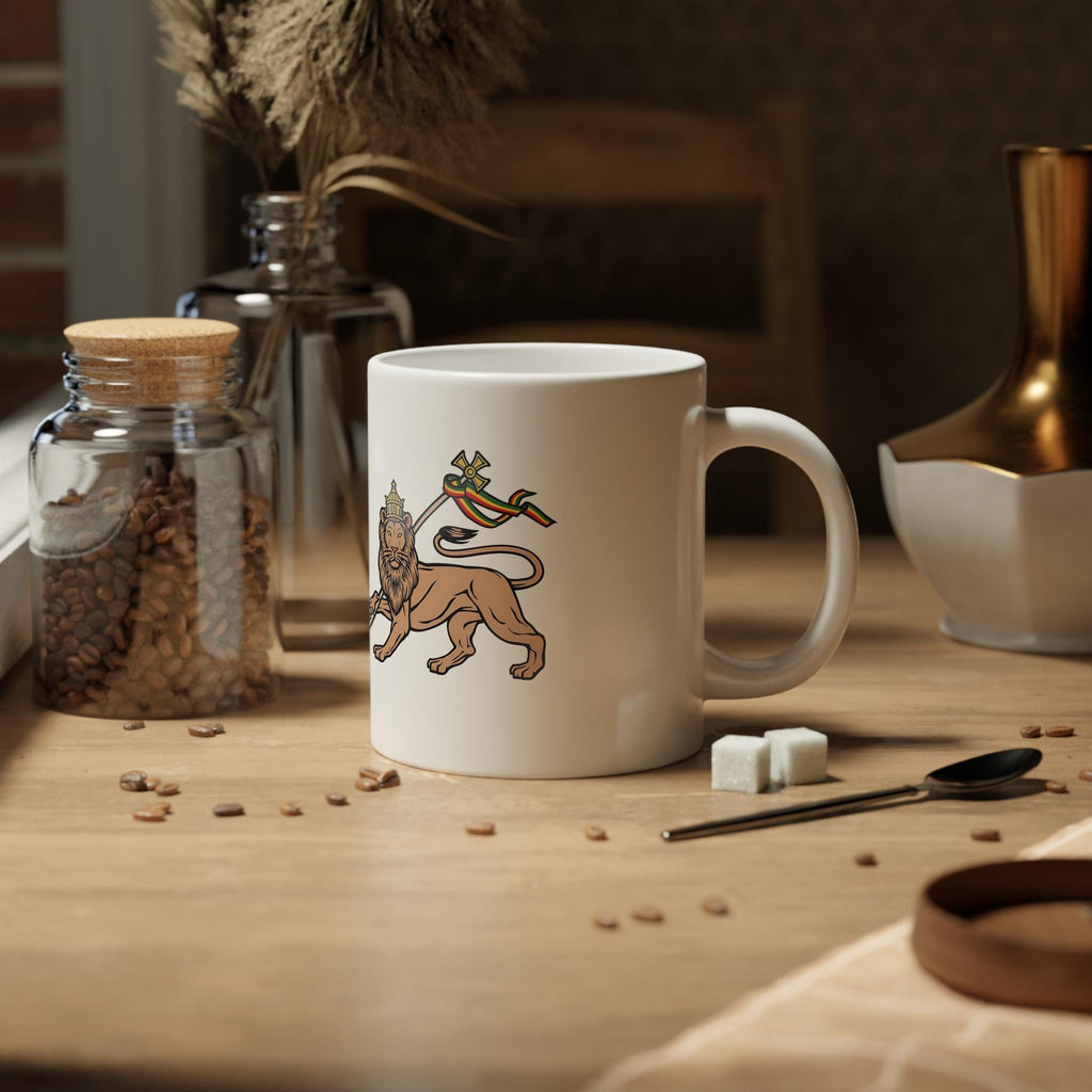 A white ceramic mug with a printed illustration of a lion and a colorful bird, styled on a wooden table with coffee beans, sugar cubes, and decorative jars.