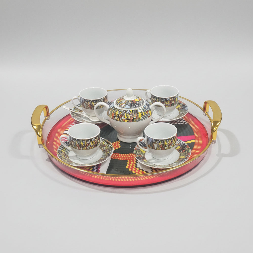 A ceramic coffee or tea set arranged on a round decorative tray with gold handles. The set includes a teapot, sugar bowl, and four matching cups and saucers, all decorated with a colorful illustrated border.