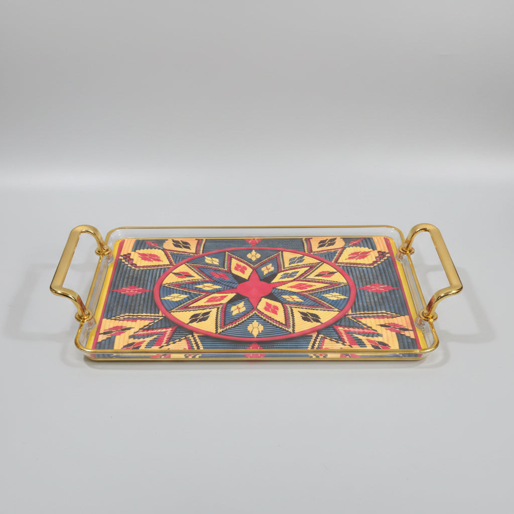 A rectangular decorative tray with gold-toned metal handles and a colorful Southwestern geometric pattern, shown on a black marble surface.