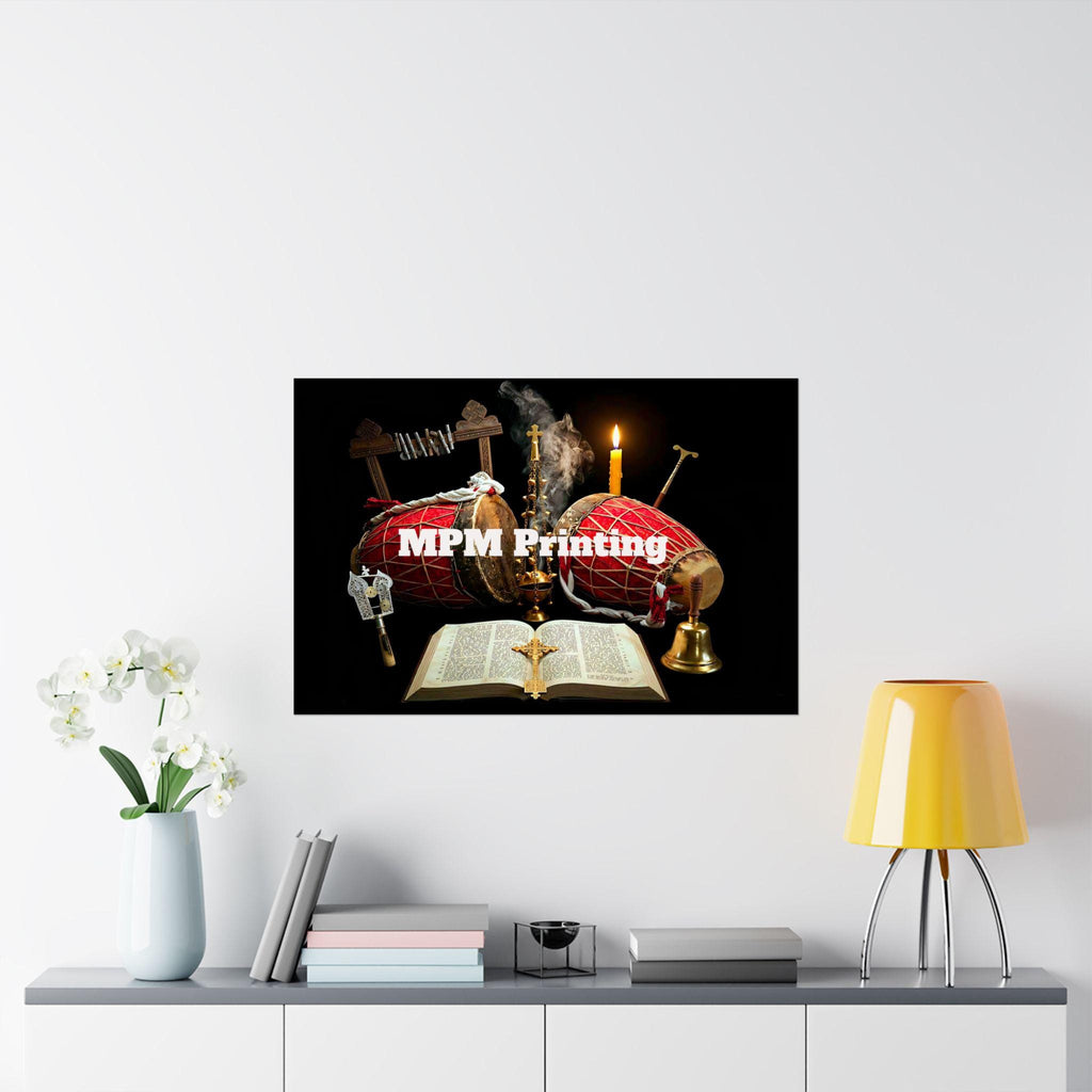 A framed-style wall print showing a black background with a red shroud, candles, an open Bible, and crosses, hung on a white wall above a shelf with flowers, books, and a yellow lamp. The print has the text 'MPM Printing' across the center.