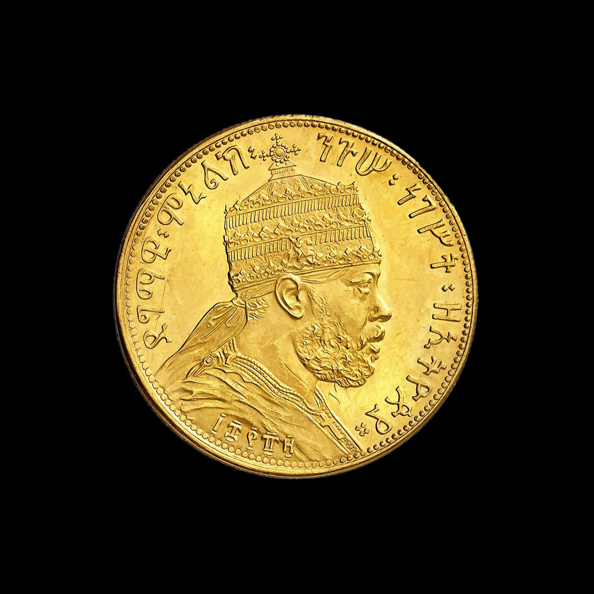 A round gold coin featuring a detailed profile portrait of a Ethiopian emperor Menelik II wearing a crown, surrounded by inscribed script, shown against a solid black background.