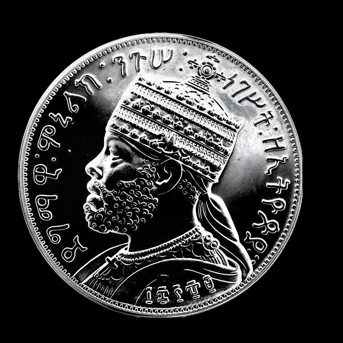 A round silver-colored coin featuring a detailed profile portrait of a emperor Menelik.