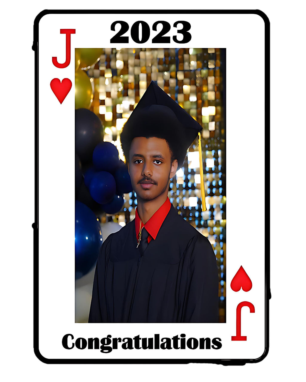 A graduation-themed playing card design with the text 'J', '2023', and 'Congratulations' on a white card face. The center photo shows a person in a black graduation cap and gown with a red shirt, set against a gold sequin backdrop with blue balloons.